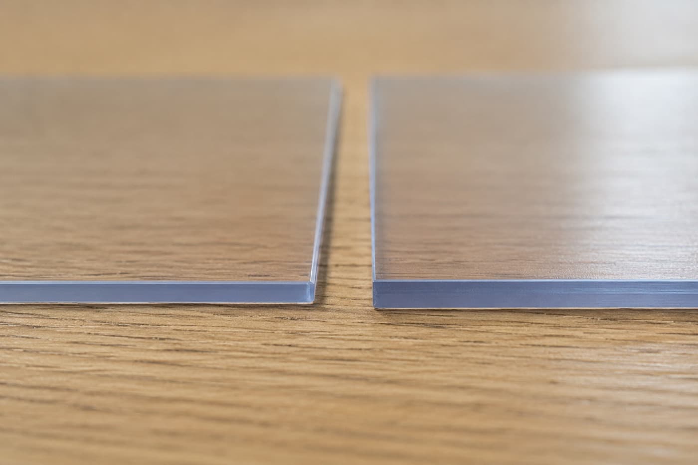 Porównanie grubości krawędzi maty ochronnej 1,5 mm i 2,0 mm z miękkiego szkła leżących obok siebie